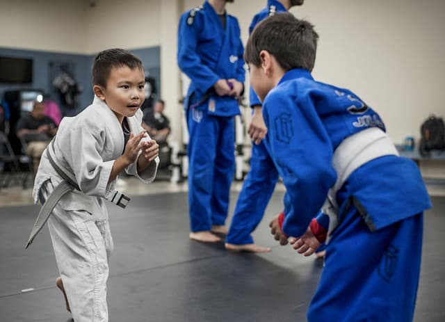 Two children engaging in jiu jitsu